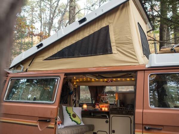 Inside my converted VW Westfalia — cozy setup with fairy lights and kitchenette